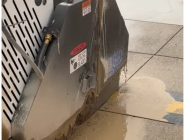 A diamond bladed saw cutting concrete paving slabs.