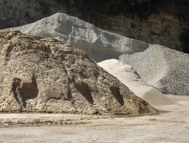 Two piles of aggregate on a quarry floor