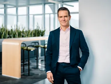 Dr Dominik von Achten, in dark suit and open neck shirt, standing in an empty office, has been elected the new president of GCCA, is chairman of the managing board at Heidelberg Materials
