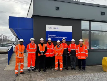 The Hyperion Robotics and National Grid teams, all in orange PPE, stand outside the Deeside Centre for Innovation, National Grid’s advanced testing facility in North Wales.