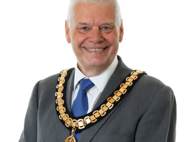 A photo of Paul Gandy, president, CIOB, wearing a grey suit, white shirt, blue tie and ceremonial chain.