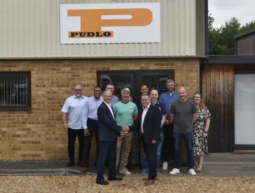 Malcolm Thornton and Scott Wilson (shaking hands) pictured with the PUDLO team outside their office following the deal to buy the company.