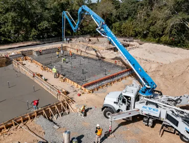A concrete pump places concrete during construction of foundations