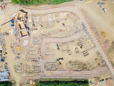 A drone shot of a new housing estate under construction showing the foundations of the new houses