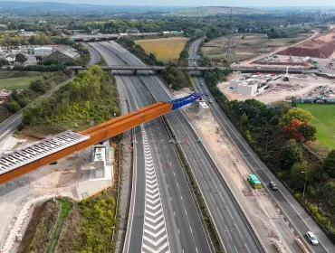 An aerial view of The HS2 viaduct East Deck being slid into place over the M6, supported by four pairs of reinforced concrete piers.