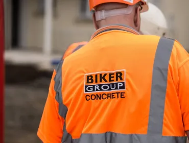 A construction worker in Biker Group branded orange PPE and hard hat