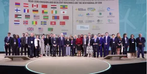 Lots of people standing on a podium with their countries flags in the background following the launch of the UAE and Canada's Breakthrough Initiative at COp28