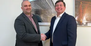 Two men shaking hads in a badly lit and composed photo