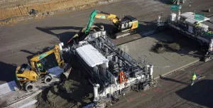 An aerial view of some men and machines repairing a concrete road