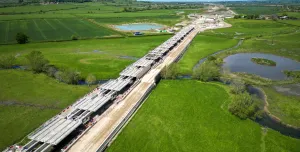 Aerial view of a Viaduct under construction surrounded by green fields