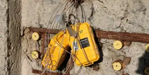 yellow boxes with lots of wires hanging on a newly poured concrete wall