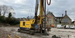 A yellow drilling rig on a constreuction site
