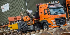 An orange HGV carrying an orange piling rig