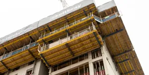 The top of an under construction building surrounded by yellow formwork