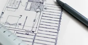 A black pen and a plan of a house with a white ruler