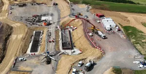 An aerial photo of a construction site with a red concrete pump