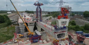 An aerial picture of a viaduct under construction with a yellow crane and red formwork.