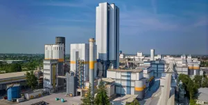 A white, grey and yellow cement plant against a blue sky