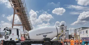 A white cement mixer and men in orange PPE