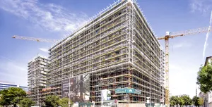 An under construction mid-rise building covered in scaffolding