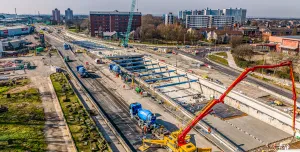 An aerial view of Ashcourt Concrete's 1,200m³ concrete pour for the A63 underpass project in Hull, showing a blue crawler crane and a yellow and red concrete pump.