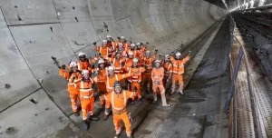 A group of construction workers gather in a tunnel to celebrate the completion of a 5 mile long tunnel under London as part of HS2