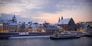 Sunset over Maastricht's docks, with a boat on the water.