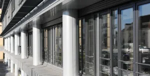 A glass fronted office with concrete columns.