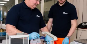 Two men in black and safety goggles working on Cemex’s Prime admixtures in its lab 