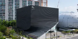 An exterior view of the Photography Seoul Museum of Art (Photo SeMA) features a distinctive twisted silhouette, created using a rhythmic layering of angled precast concrete panels.