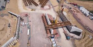 A yellow crane lifts beams into place for the Gloucestershire Way bridge, which will span the new A417 Missing Link and eight lanes of traffic