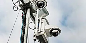 A close-up view looking up at two solar powered CCTV cameras mounted on a pole.
