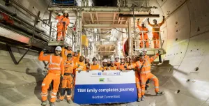 A large group of people in orange PPE, part of HS2 tunnelling team celebrates, TBM Emily completing 5.5km journey. Image: HS2.