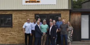 Malcolm Thornton and Scott Wilson (shaking hands) pictured with the PUDLO team outside their office following the deal to buy the company.