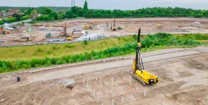 A yellow foundation rig prepares to start work at a large housing project in St Helens.