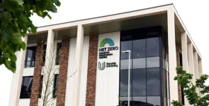 An external view of Teeside University’s Net Zero Industry Innovation Centre (NZIIC), a multi-storey building with a glass, red brick and white render facade.