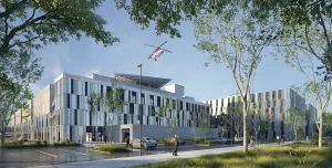 A red helicopter flies over the new Caen University Hospital, which features 110,000 m² of healthcare space built using lower-carbon concrete. Photo Credit: ©CHU de Caen Normandie