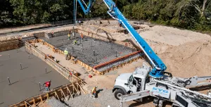 A concrete pump places concrete during construction of foundations