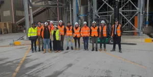 A group of people in yellow and orange PPE from Material Evolution, CRH, CRH Ventures & Tarmac at the Mevo A1 Production Facility in Llay, Wales