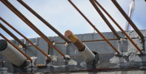 Metal rebar protruding from the end of a concrete beam.