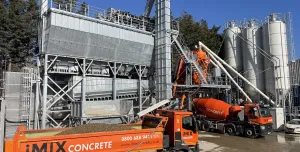 An orange tipper truck and orange cement mixer wait by the new iMIX plant in Essex is MCT Italy’s first UK ready-mix installation, built for high-volume output and flexibility.