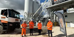 Four people in orange PPE stand in front of Biker Group’s new Stockton-on-Tees concrete plant, which represents a £1.5 million investment in the region.