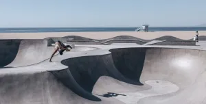 2024/25 Concrete in Life Winner, Venice Beach Skating by Henrik Hagerup shows a single skateboarder performing tricks at a concrete skatepark with the sea and beach in the background