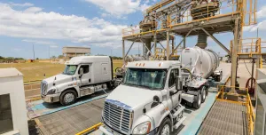 Two US trucks load up with materials at Eco Material Technologies, which supplies supplementary cementitious materials, critical for reducing embodied carbon in concrete.