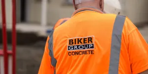 A construction worker in Biker Group branded orange PPE and hard hat