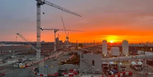 Sunrise over the construction of Old Oak Common Station in London, one of several HS2 sites supplied by Holcim UK, with a tower silhouetted against a setting sun