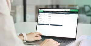 A close up of someone's hands working on a laptop