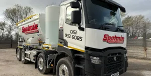 A white screed truck with red decals