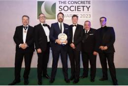 A group of men in dinner suits collect an award