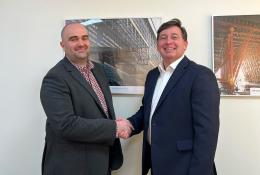 Two men shaking hads in a badly lit and composed photo